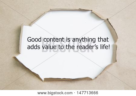 The quote Good content is anything that adds value to the readers life, appearing behind torn brown paper.