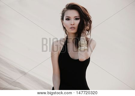 Professional photo shoot in desert. Beautiful sexy asian woman model in desert