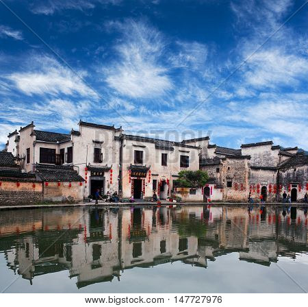 HONGCUN, CHINA - APRIL 20, 2014: Tourist walking along Moon Lake in ancient Hongcun Village.