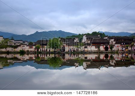 HONGCUN, CHINA - APRIL 20, 2014: Tourist walking around Moon Lake in the ancient Hongcun Village.