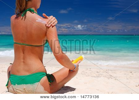Tan kvinde anvender sun protection lotion