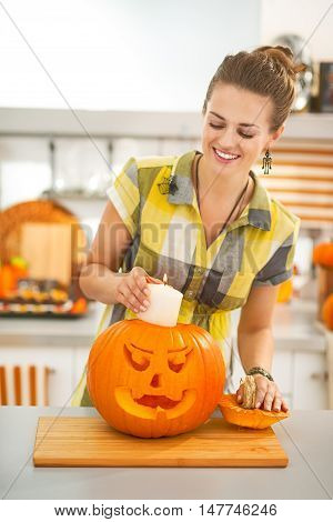 Housewife Putting Candle Inside Orange Pumpkin Jack-o-lantern