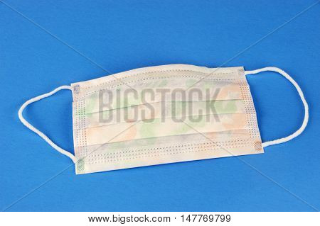 single medical ear-loop mask on blue background