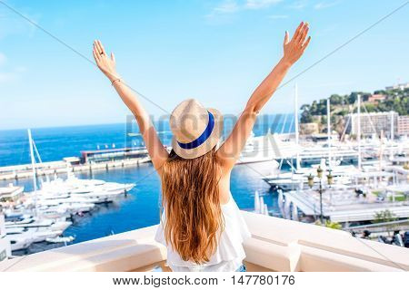 Young female traveler enjoying great view on the harbor with yachts in Monte Carlo in Monaco