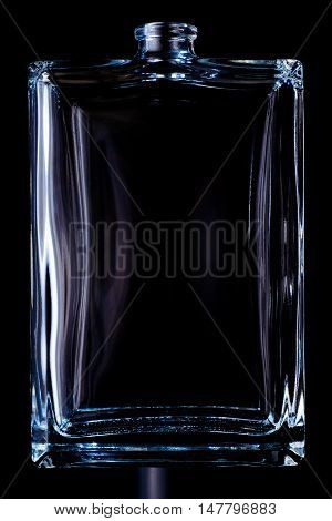 Rectangular transparent bottle of cologne isolated on a black background.