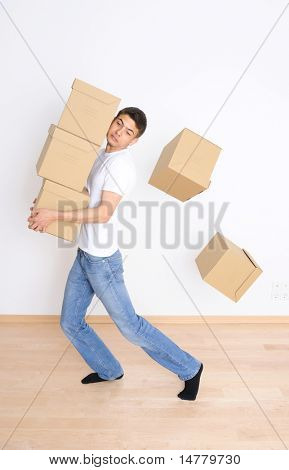 Giovane uomo che trasportano e far cadere il suo stack di spostamento scatole