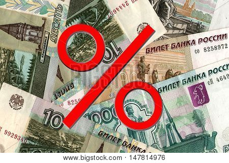 Red percent sign on a background of money . The concept of price changes on the real estate market