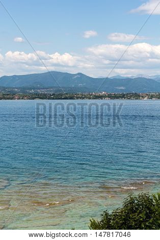 Landscape of the coast of Sirmione peninsula which divides the lower part of Lake Garda. It is a famous vacation place for a long time in northern Italy.