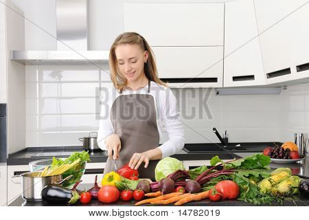 Woman cooking in modern kitchen, chopping pepper