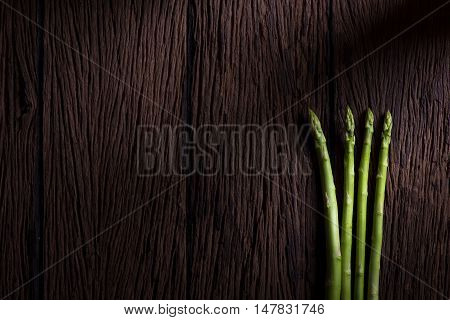Bunches of asparagus on a wood background.