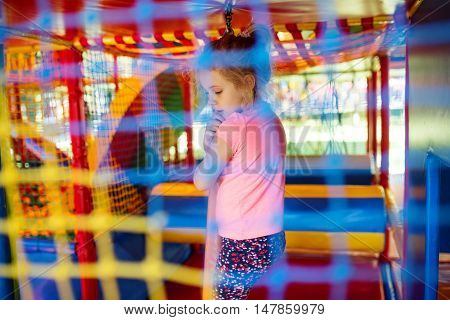 Cute little girl have fun at soft outdoor playground.