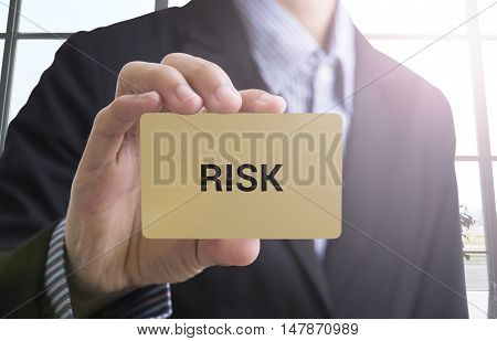 businessman hand holding a business card with a message risk management to success concept.