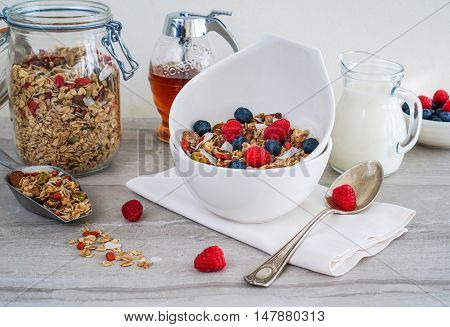 Healthy Coconut Granola with Nuts, Gogi Berry and Berries in White Ceramic Bowl. Healthy breakfast. Selective focus.