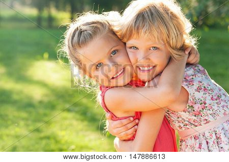 Portrait of Two Little Girlfriends / Sisters Hugging