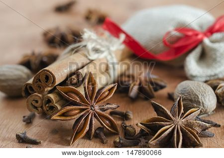 Spices for mulled wine. Closeup of cinnamon sticks anise stars and cloves on wooden background. Selective focus. Macro with shallow dof.
