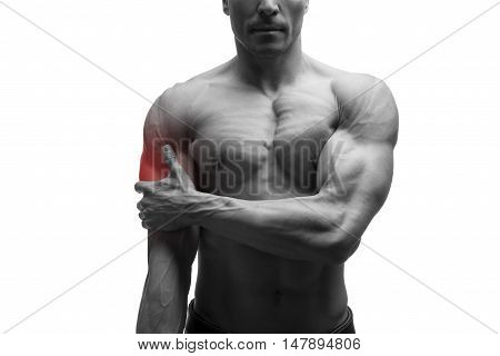 Man with pain in shoulder ache in muscular male body isolated on white background with red dot black and white photo
