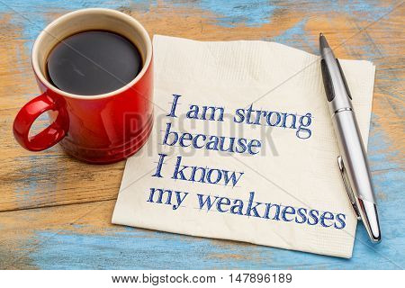 I am strong because I know my weaknesses - handwriting on a napkin with a cup of espresso coffee