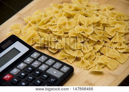 Calulator With Pasta On Wooden Background, Calories