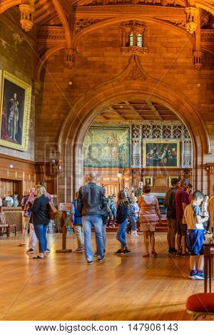 AUGUST 12, 2016--BAMBURGH, ENGLAND--Visitors to Bamburgh Castle in Bamburgh England look at the Great Hall of the castle and admire the beauty of the interior of the castle.