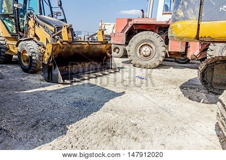 View on front end of loader backhoe tractor parked at construction site.