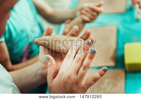 children's hands sculpts clay crafts pottery school