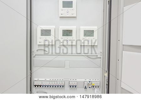 Smart home automation: display showing household consumptions related to temperature and heating. Automatic fuse electrical connector in power lines located inside of switch control panel board.