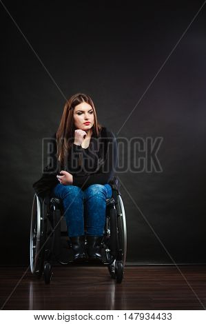 Sad girl sitting on wheelchair. Disabled depressed woman. Health medical disability rehabilitation concept.