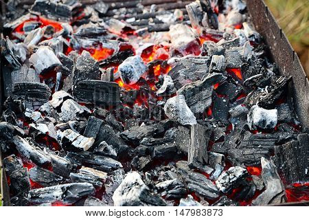 bright hot flame and glowing pieces of charcoal in the brazier