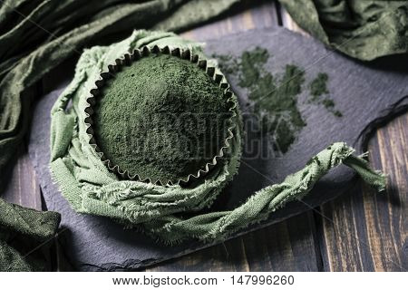 Spirulina powder on a wooden background