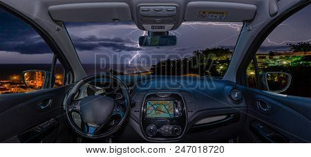 Looking Through A Car Windshield With View Over Lightning Storm Over The Sea
