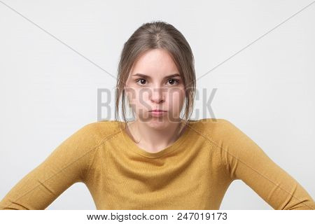 Young European Woman In Yellow Sweater Looking With Offended Look, Being Dissatisfied With Something