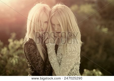 Beauty Fashion Portrait. Contrasts And Opposites Concept. Sisters Twins Posing On Sunny Natural Land