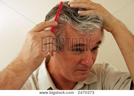 Sênior cavalheiro penteando seu cabelo
