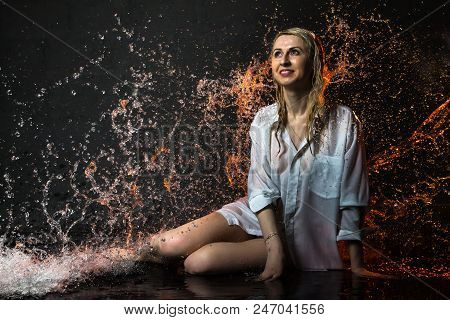 Nice Girl In The White Shirt And Water Drops Behind And Arround Her Illuminated By Light During A Ph