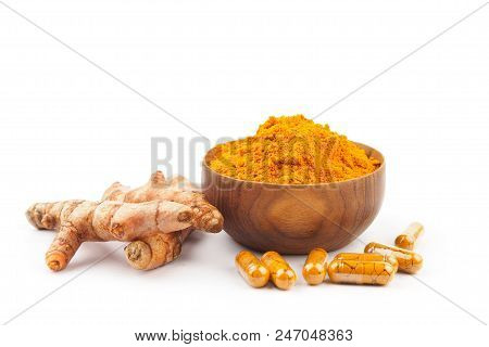 Turmeric Capsules And Turmeric Powder In Wooden Bowl On White Background. Herbal