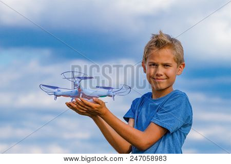 Child Playing With Drone Outdoors Against Blue Sky