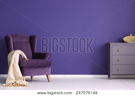 Comfy Armchair With A Blanket And Chest Of Drawers Set On An Empty Wall In A Living Room Interior, P