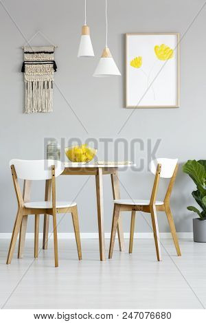 Real Photo Of A Simple, Natural Dining Room Interior With Lamps And Poster With Yellow Flowers Above