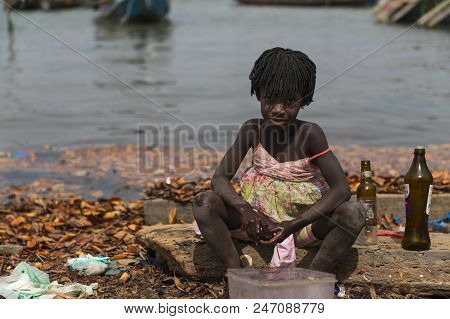 Cacheu, Republic Of Guinea-bissau - February 1, 2018: Young Girl Washing Bottles Next To The Water I