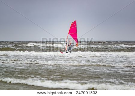 Man Windsurfing On Cloudy Windy Cold Day On Romo Island In Denmark