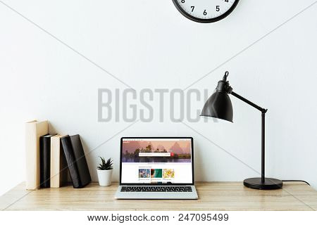 Laptop With Shutterstock Website On Screen On Work Table At Office