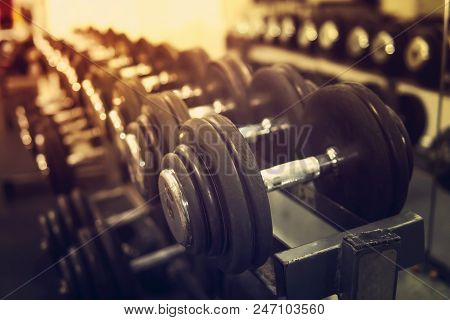 Rows Of Dumbbells In The Gym With Hign Contrast And Monochrome Color Tone. Concept Of Bodybuilding.