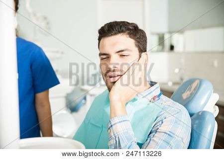 Mid Adult Man Suffering From Toothache While Sitting By Dentist In Dental Clinic