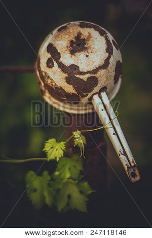 Old Rusty Ladle Hanging On The Vineyard In The Garden
