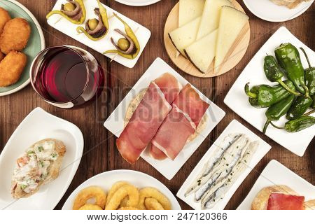 The Food Of Spain. An Overhead Closeup Photo Of Various Spanish Tapas, Shot From Above On A Dark Rus