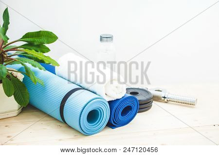Set For Sports, A Yoga Mat, A Towel, A Dumbbell And A Bottle Of Water On A Light Background. The Con