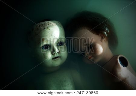 Creepy dolls in dark dirty water 