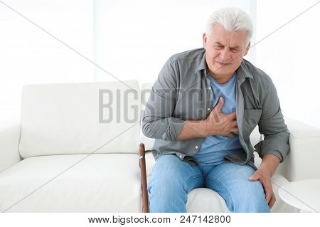Senior Man Having Heart Attack On Sofa