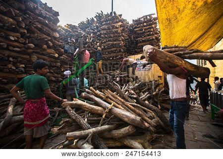VARANASI, INDIA - MAR 22, 2018: Locals near Holy Ganges weighed for sale wood for cremation. Manikarnika Ghat is one of the ghats in Varanasi and is most known for being a place of Hindu cremation.