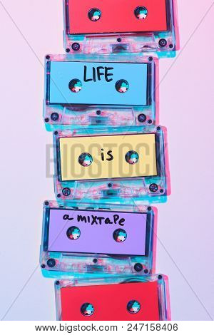 Top View Of Arranged Colorful Audio Cassettes With Life Is A Mixtape Inscription On Purple Backgroun